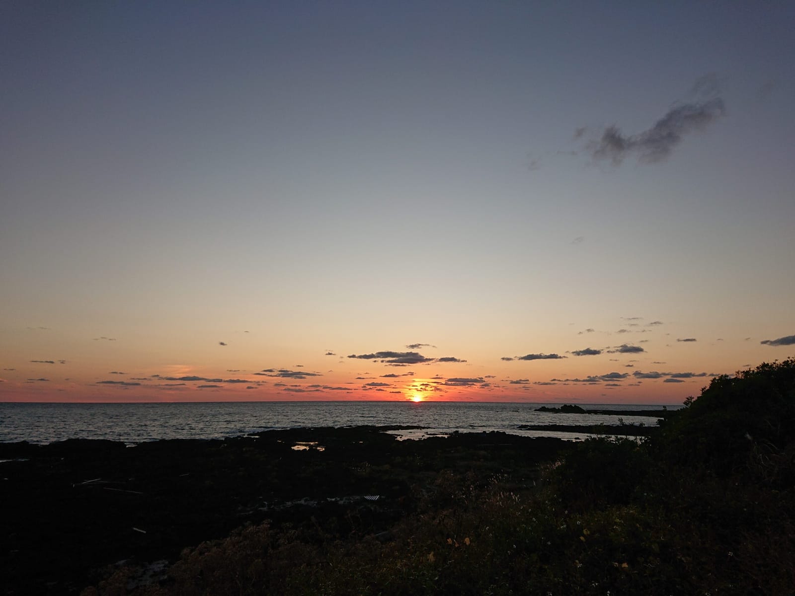 海に沈む夕日を眺める