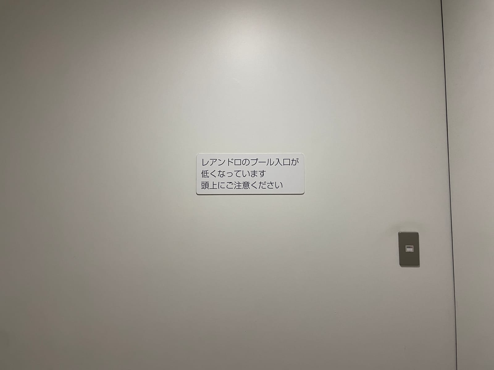 「レアンドロのプール入口が低くなっています 頭上にご注意ください」レアンドロ・エルリッヒ『スイミング・プール』へ向かう通路の注意書き