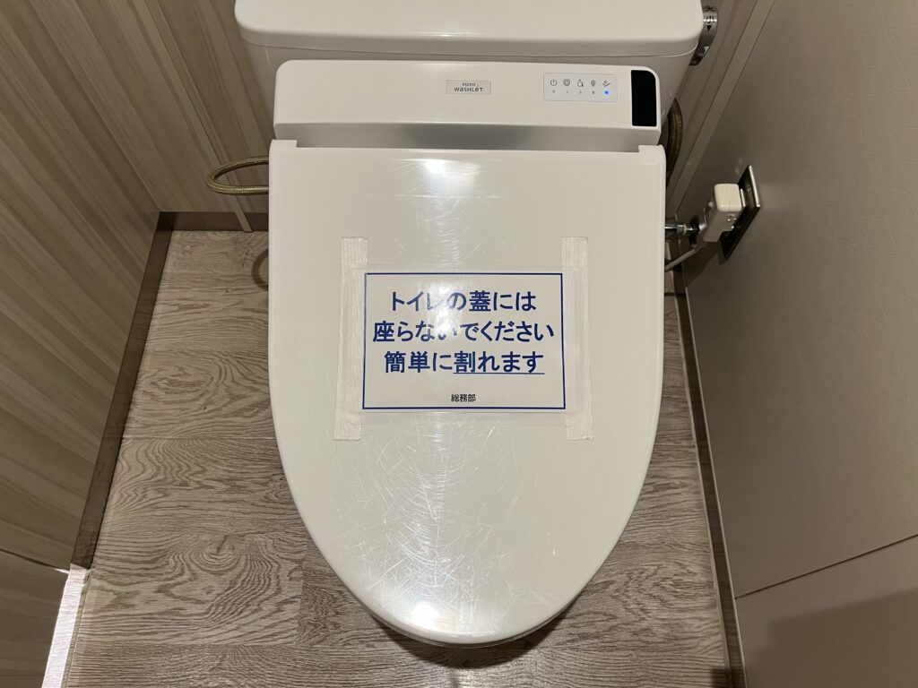 「トイレの蓋には座らないでください　簡単に割れます」総務部